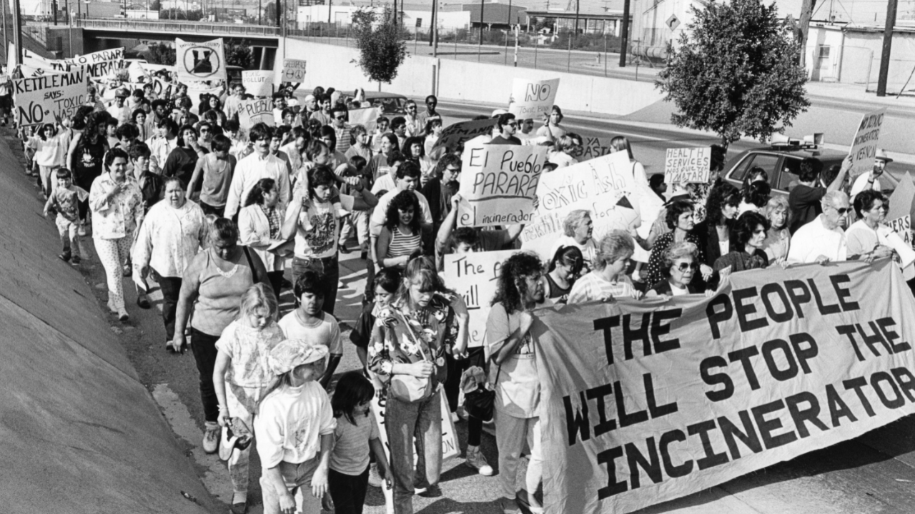 Peopl marching with a sign to "Stop the Incinerator"