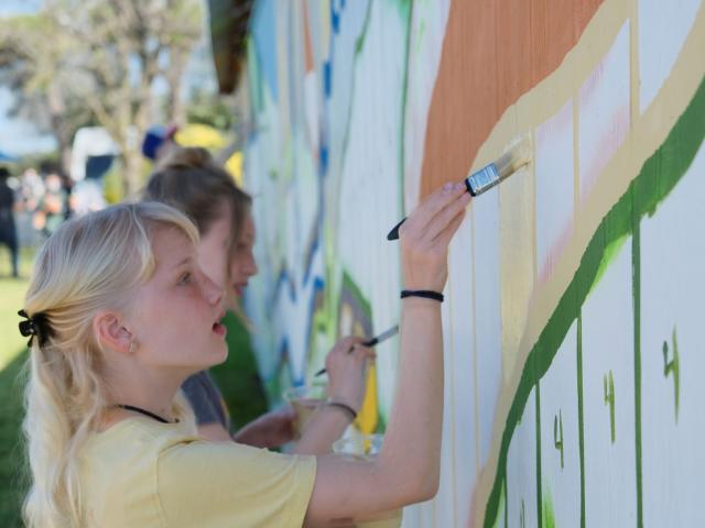 Young Person Painting Side of Barn