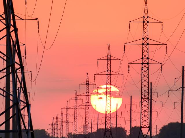 High power lines backlit by a setting sun