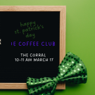 A green bow tie rests beside a chalkboard announcing a St. Patrick's Day coffee club.