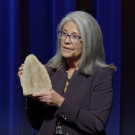 Institute Director stage, holding up a cross-section of a cave formation